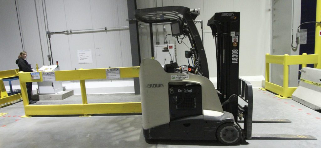 Text Box: Hydrogen powered forklift at Walmart Balzac distribution center. Walmart was a pioneer in large scale adoption of hydrogen fuel cell forklifts. There are over 20,000 hydrogen fuel cell forklifts in the U.S. Increased uptime (refueling in 3-5 minutes), small footprint and sustained performance are cited as major benefits. 
Photo: David Dodge, Green Energy Futures.
